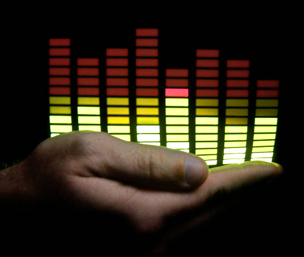 An open palm appearing to hold the bars of a graphic equalizer